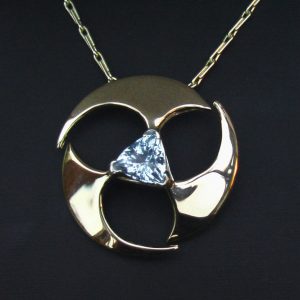 Yellow gold pendant set with a trillion cut aquamarine.